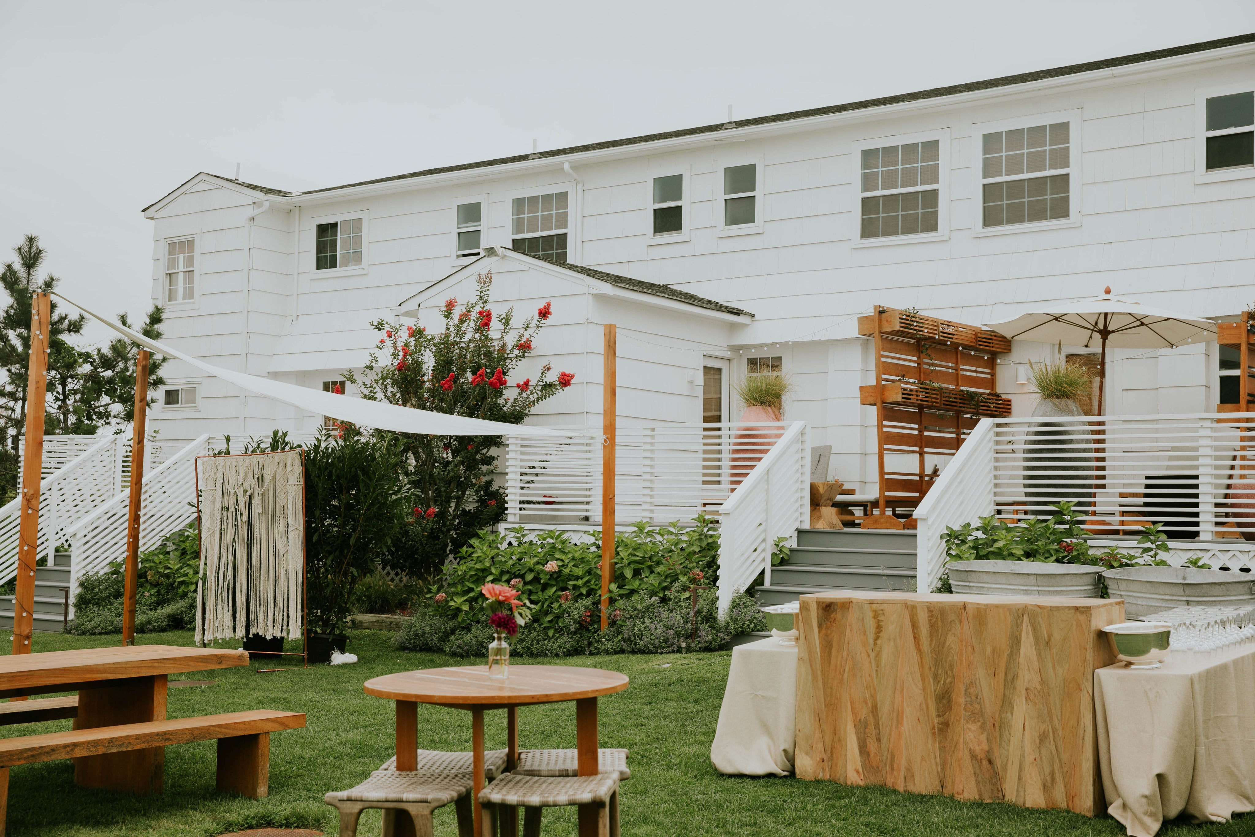 Backyard over to White story, building ready for accepting guests with a lot of flowers and cosy places to chill